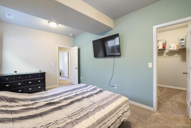 bedroom featuring carpet flooring, a spacious closet, and a closet