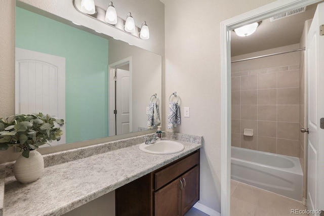 bathroom with tile patterned flooring, vanity, and tiled shower / bath combo