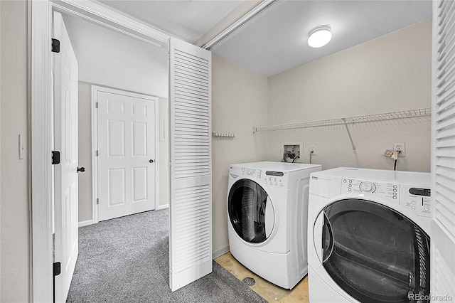 clothes washing area featuring laundry area, baseboards, light colored carpet, and washing machine and clothes dryer