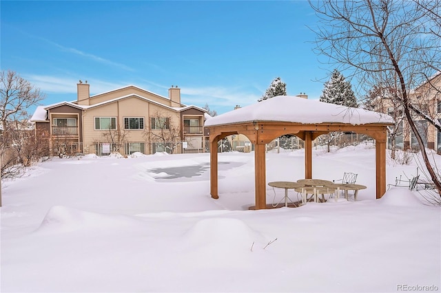 yard layered in snow with a gazebo