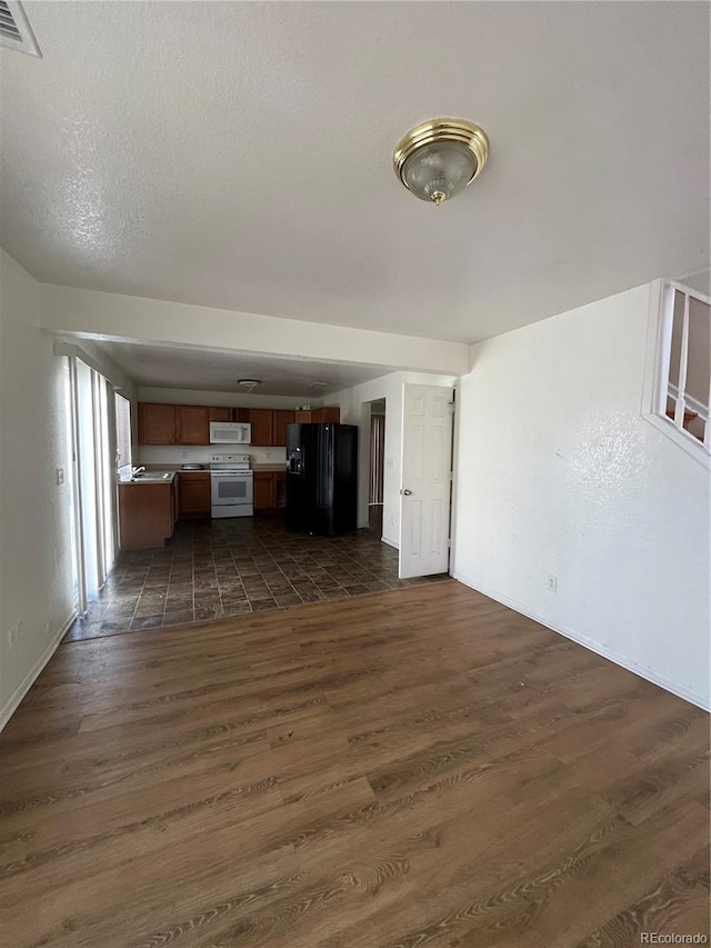 unfurnished living room featuring a textured ceiling and dark hardwood / wood-style flooring