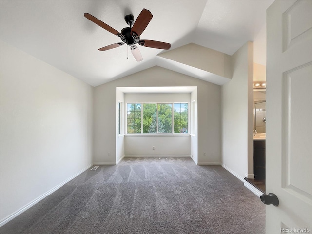 unfurnished room featuring dark carpet, ceiling fan, and lofted ceiling