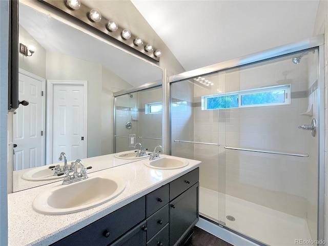 bathroom featuring a shower with door, vanity, and lofted ceiling