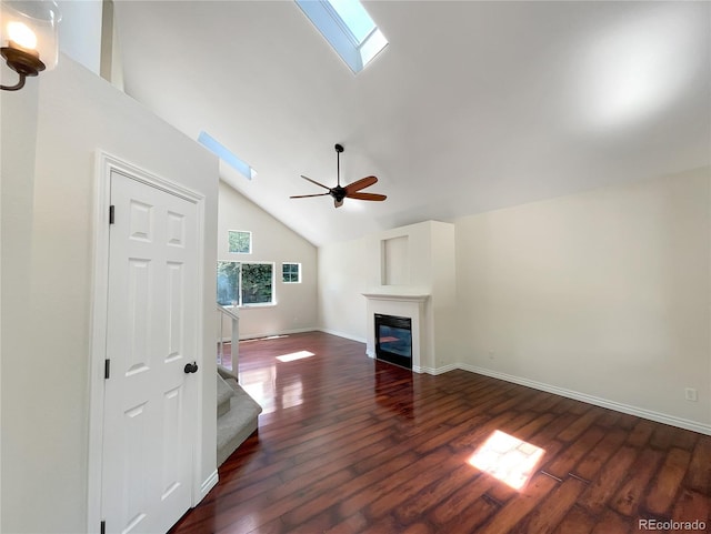 unfurnished living room featuring a skylight, dark hardwood / wood-style floors, high vaulted ceiling, and ceiling fan