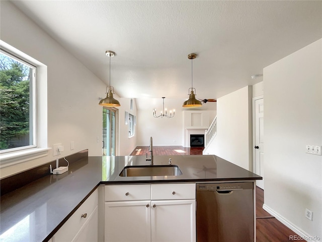 kitchen with dishwasher, white cabinets, sink, hanging light fixtures, and dark hardwood / wood-style flooring