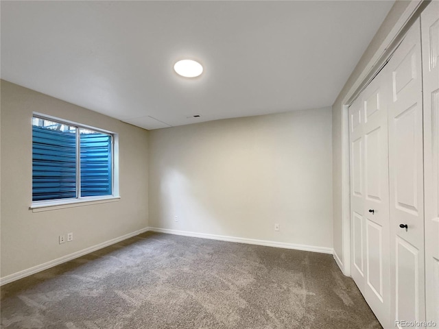 unfurnished bedroom featuring a closet and dark carpet