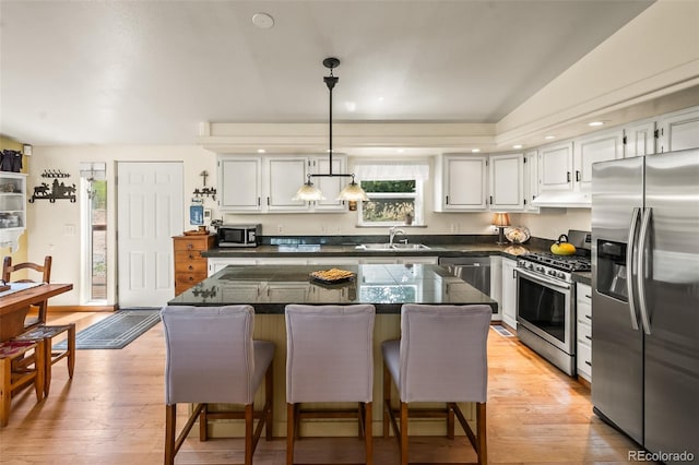 7260 Remington Rd, Como, CO 80432 - kitchen featuring appliances with stainless steel finishes, a sink, under cabinet range hood, white cabinets, and plenty of natural light