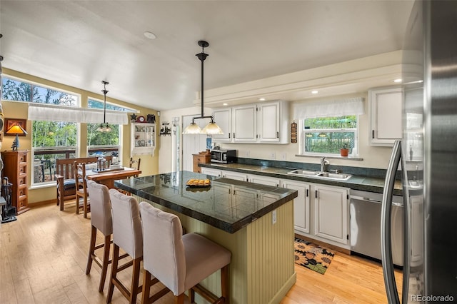7260 Remington Rd, Como, CO 80432 - kitchen with tile counters, a sink, appliances with stainless steel finishes, a kitchen island, and a kitchen bar
