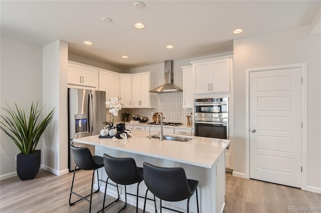 6581 E 148th Dr, Thornton, CO 80602 - kitchen featuring stainless steel appliances, wall chimney range hood, light countertops, white cabinetry, and recessed lighting