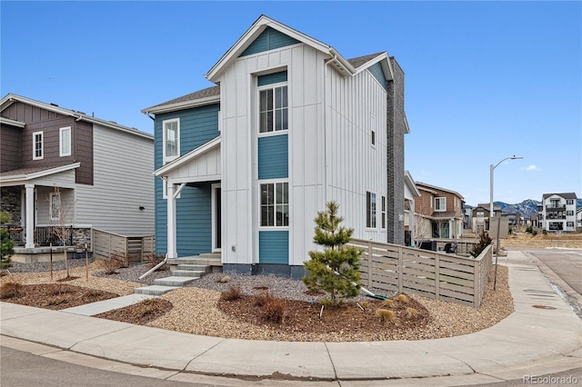 view of front of house with a residential view, fence, and board and batten siding