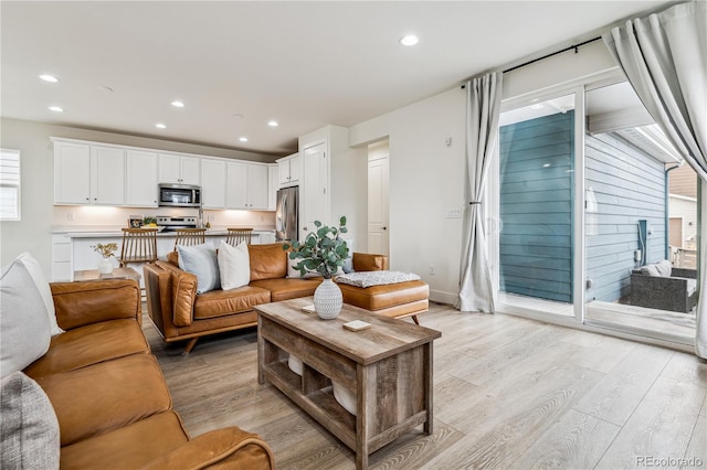 living room with baseboards, light wood-style flooring, and recessed lighting