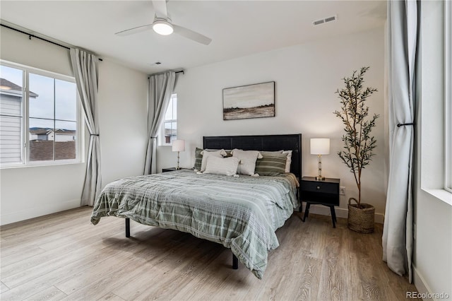 bedroom featuring baseboards, visible vents, and wood finished floors