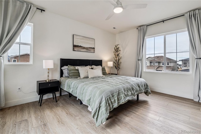 bedroom with baseboards, light wood-style floors, and ceiling fan