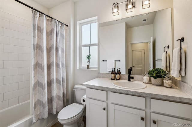 bathroom featuring visible vents, toilet, vanity, and shower / bath combo