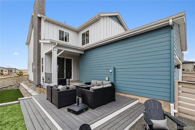 rear view of property featuring board and batten siding, an outdoor hangout area, fence, and a deck