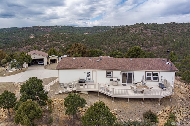 rear view of property with a deck and a garage