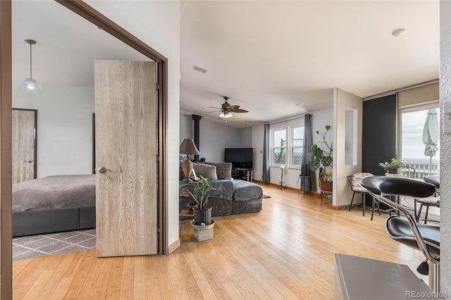 living room featuring ceiling fan, lofted ceiling, and light hardwood / wood-style flooring