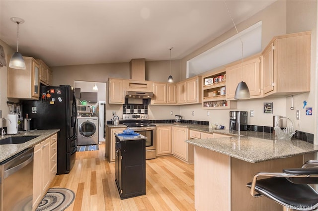 kitchen featuring appliances with stainless steel finishes, pendant lighting, washer / dryer, sink, and kitchen peninsula