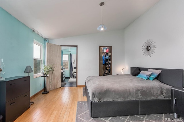 bedroom with vaulted ceiling and light hardwood / wood-style flooring