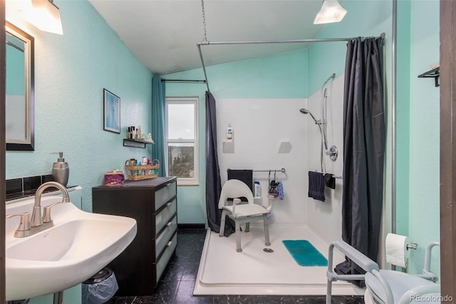 bathroom with lofted ceiling, sink, and walk in shower