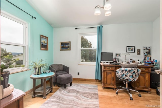 office featuring an inviting chandelier and light hardwood / wood-style floors