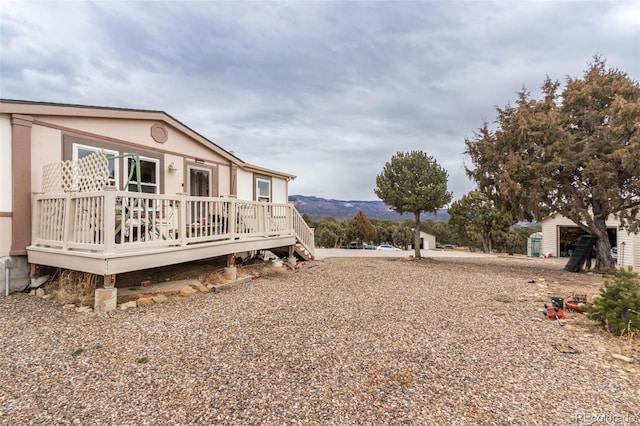 view of yard featuring a deck with mountain view and a shed