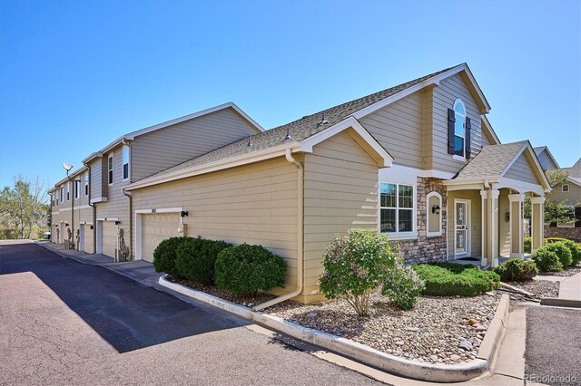 6033 Trailhead Rd, Highlands Ranch, CO 80130 - view of property exterior featuring driveway, a shingled roof, and stone siding
