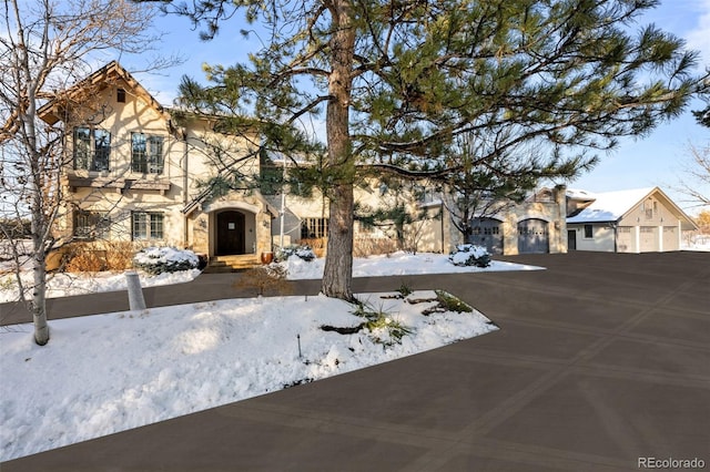 view of front of home featuring a garage, stone siding, and stucco siding