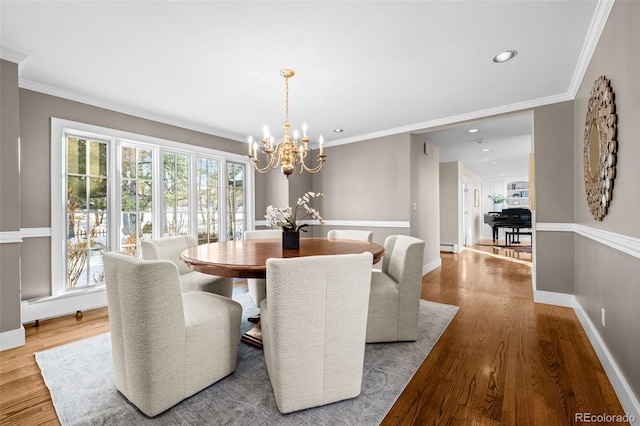 dining room featuring an inviting chandelier, recessed lighting, wood finished floors, and a healthy amount of sunlight
