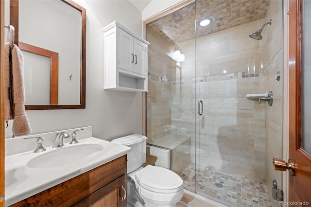 bathroom with vanity, toilet, and a shower stall