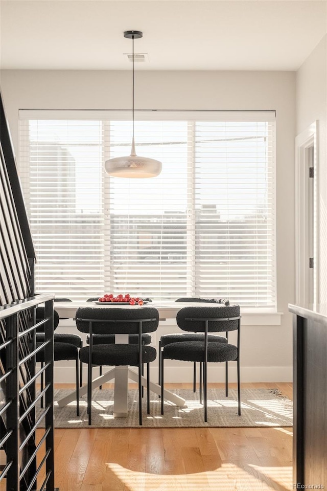 dining area with visible vents, baseboards, a healthy amount of sunlight, and wood finished floors