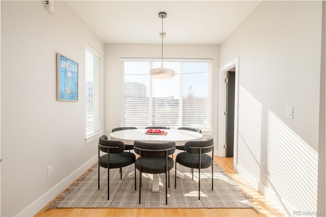 dining area featuring light wood-style floors and baseboards