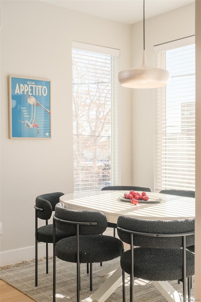 dining area with baseboards and wood finished floors