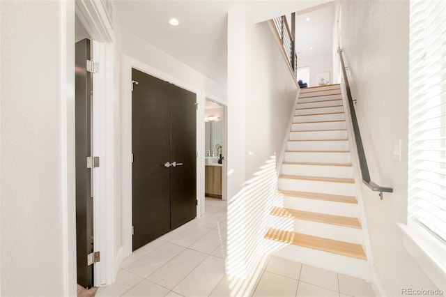 stairs with tile patterned floors and recessed lighting