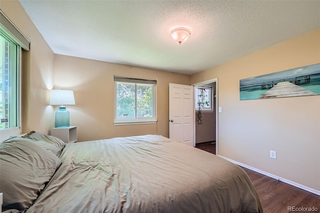 305 Cottonwood Ct, Longmont, CO 80501 - bedroom with dark wood-style flooring, baseboards, and a textured ceiling