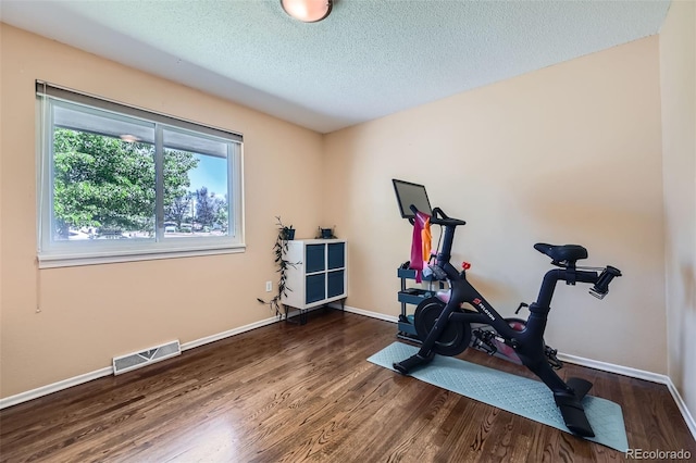 305 Cottonwood Ct, Longmont, CO 80501 - workout area with wood finished floors, baseboards, and a textured ceiling