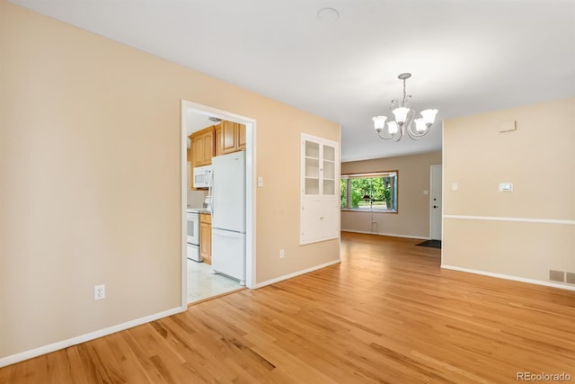 2698 S Niagara St, Denver, CO 80224 - empty room featuring a chandelier and light wood-style flooring