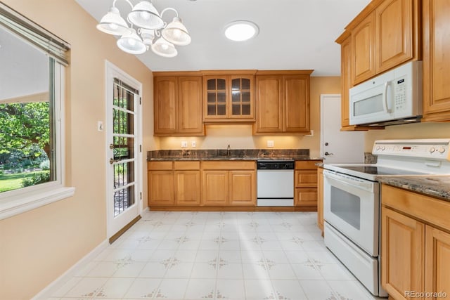 2698 S Niagara St, Denver, CO 80224 - kitchen featuring white appliances, light flooring, a chandelier, glass insert cabinets, and dark stone countertops