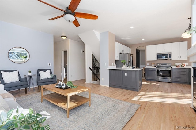 living room featuring ceiling fan and light hardwood / wood-style flooring