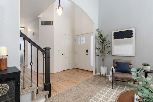 entryway with a high ceiling and carpet floors