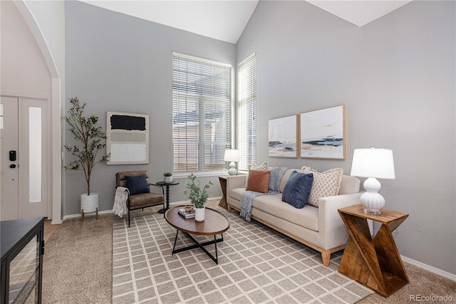 carpeted living room featuring high vaulted ceiling