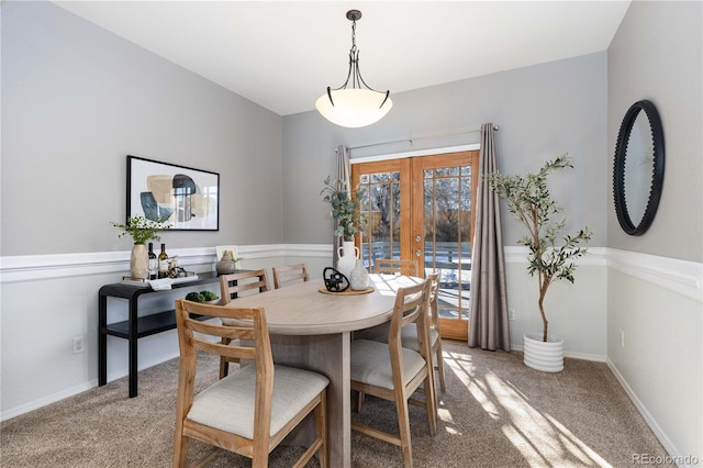 carpeted dining area featuring french doors