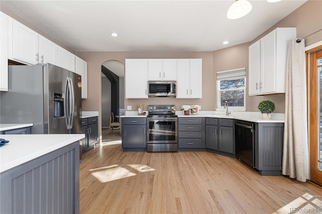 kitchen featuring light wood-type flooring, appliances with stainless steel finishes, gray cabinetry, and white cabinets