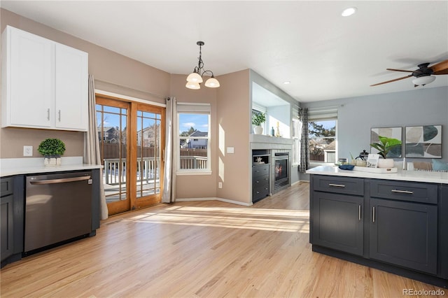 kitchen featuring pendant lighting, dishwasher, white cabinetry, light hardwood / wood-style floors, and plenty of natural light