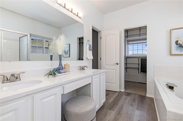 bathroom with vanity, plus walk in shower, and hardwood / wood-style flooring