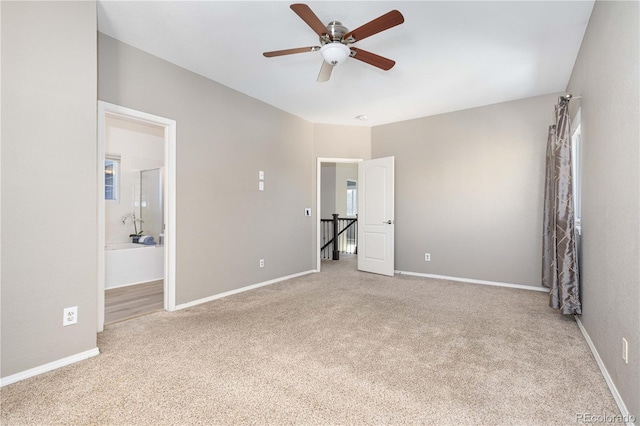 unfurnished bedroom featuring light carpet, ceiling fan, and ensuite bathroom