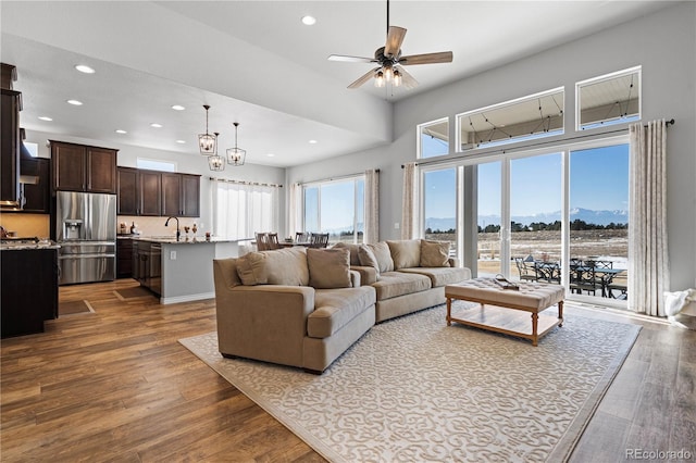 living room with ceiling fan, dark hardwood / wood-style flooring, a mountain view, and sink