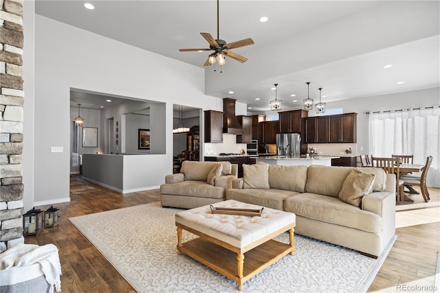 living room with hardwood / wood-style flooring and ceiling fan with notable chandelier