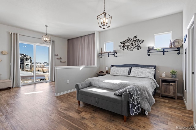 bedroom featuring multiple windows, dark hardwood / wood-style flooring, access to outside, and a chandelier