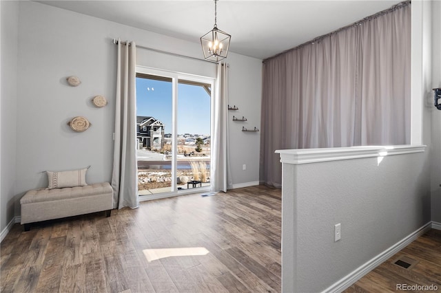 entryway featuring hardwood / wood-style floors and an inviting chandelier